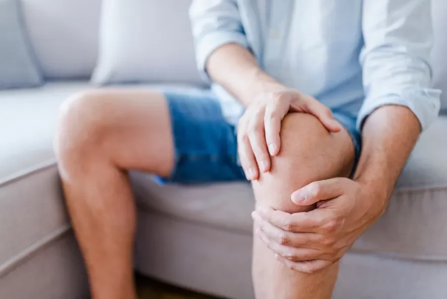 man holding knee in pain