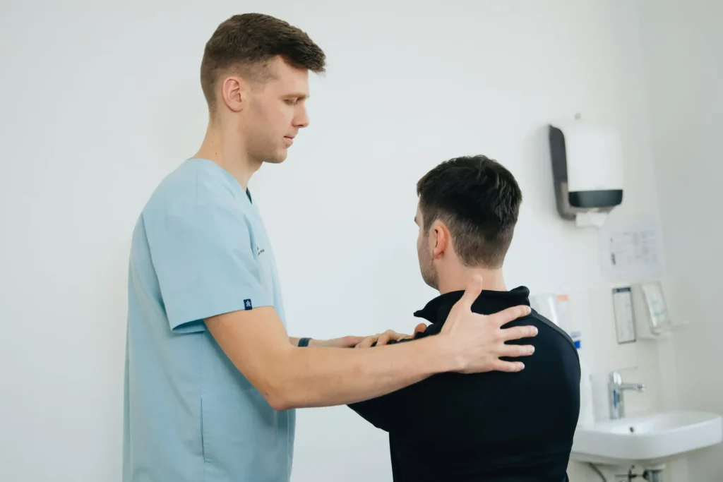 Clinician assessing shoulder movement during frozen shoulder treatment.