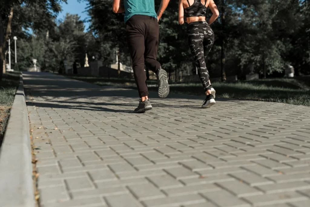 What Is Runner’s Knee? Symptoms, Causes and Treatment 2 Two runners gradually rebuilding their training on a park path.
